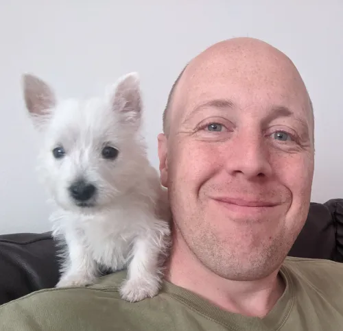 Tom with puppy Essie on his shoulder